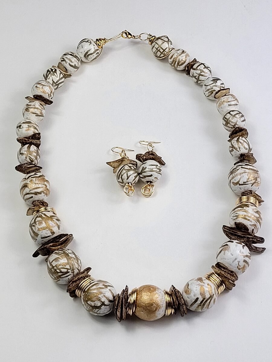 White beaded necklace with gold swirl accents.