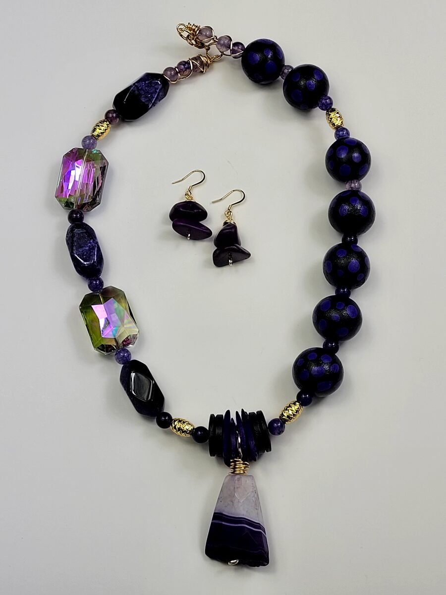 Deep purple beaded necklace with iridescent crystals and an amethyst slab pendant.